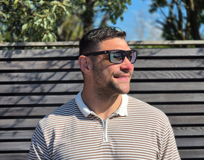 Model wearing Sport 155mm XL polarised sport sunglasses in Black with chrome lenses – bold mirrored style for round faces.