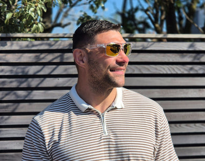 Model wearing Sport 155mm XL polarised sunglasses for round faces in Clear – bright yellow lenses and oversized comfort.