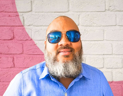 Model wearing The Arrival 165mm XXL sunglasses for big heads in Black with blue polarised lenses – modern aviator-style wide fit designed for larger head sizes.